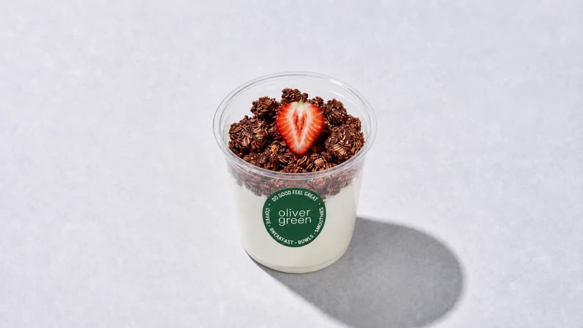 Yoghurt & Granola pot. Greek yoghurt topped with Cacao Granola and strawberry.